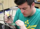 Physics teacher and TI participant Josh Leckman solders components on a project board during a TI session last summer in Colorado.